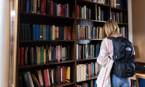 Student looking for books in a library