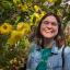 A picture of Nicola in front of some yellow flowers.