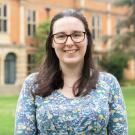 Women with brown hair and glasses standing in front of the Somerville library